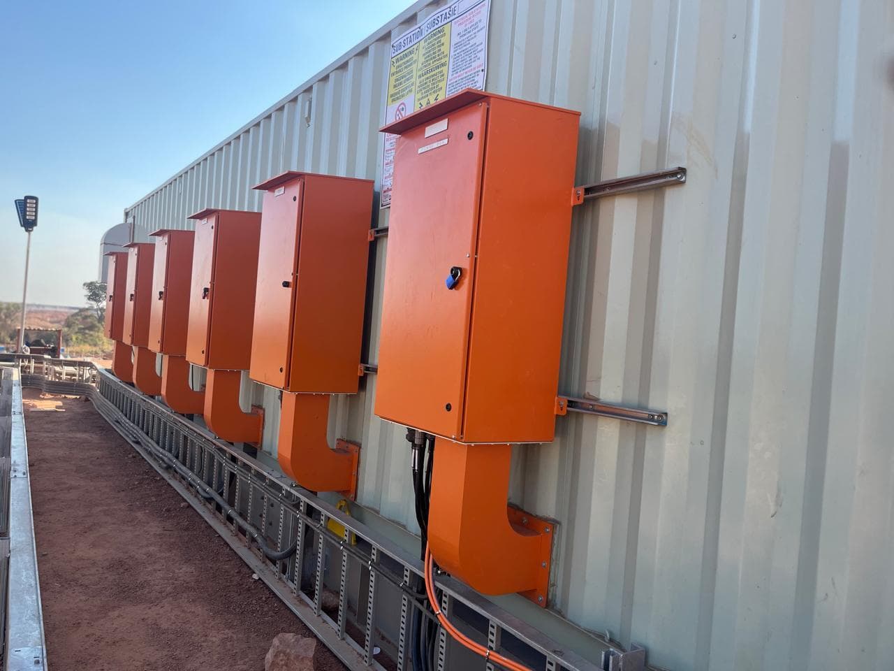 A containerised motor control centre being installed on site, with cabling run into the container from the surrounding plant.